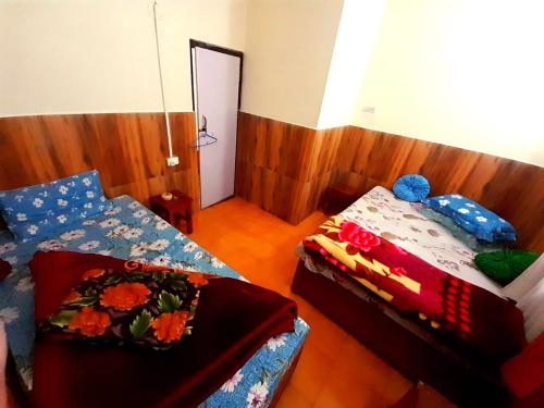 a bedroom with two beds and a mirror at International Youth Hostel and Homestay Kurseong Bazar in Kurseong