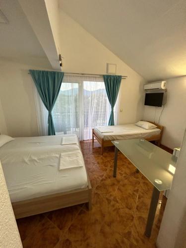 Una pequeña habitación con dos camas y una ventana. en Krašići apartmani Bozic, en Krasići