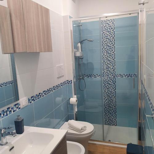 a bathroom with a shower and a toilet and a sink at Casa Acquamarina in Marina di Monasterace