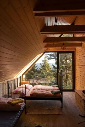 two beds in a room with a large window at Mountain Lodge Azzy, surrounded by Ultimate Peace! in Valašské Klobouky