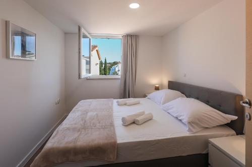 a bedroom with a large bed with two towels on it at Sea view by Moro in Malinska