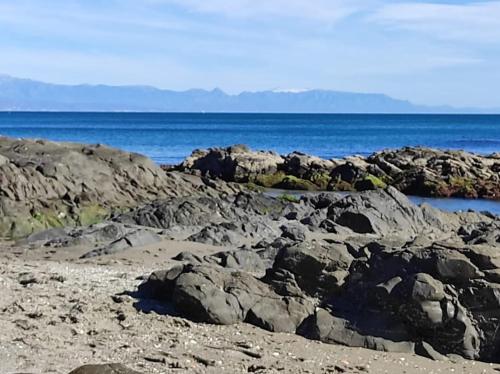 uma praia rochosa com o oceano ao fundo em Relajante apartamento junto al mar en Mijas em Mijas