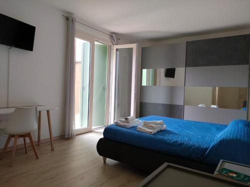 Un dormitorio con una cama azul y una ventana en Corte del Sole en Valeggio sul Mincio