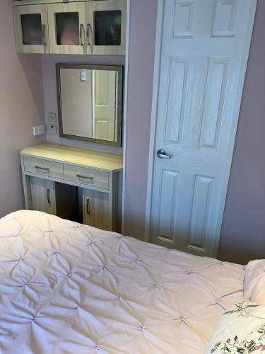 a bedroom with a bed and a mirror and a door at Petite maison dans la nature in Préveranges