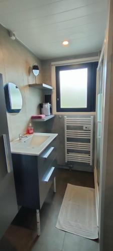 a small bathroom with a sink and a window at Aux Passagers de la Baie in Le Crotoy