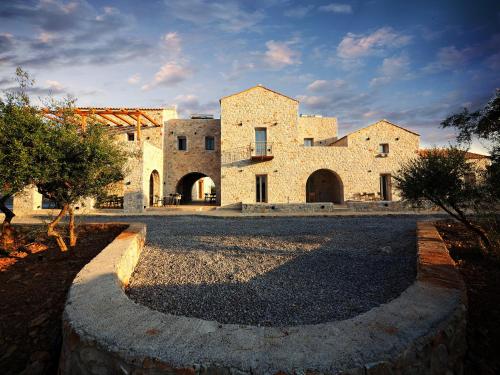 een groot stenen gebouw met een weg ervoor bij Terra Di Pietra Exclusive Suites & Apartments in Areopolis