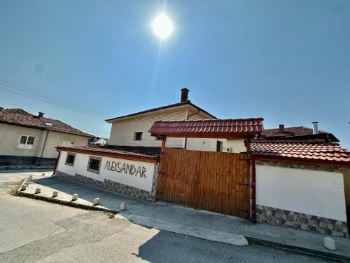 a house with a wooden fence in a parking lot at Къща за гости “Александър” in Velingrad