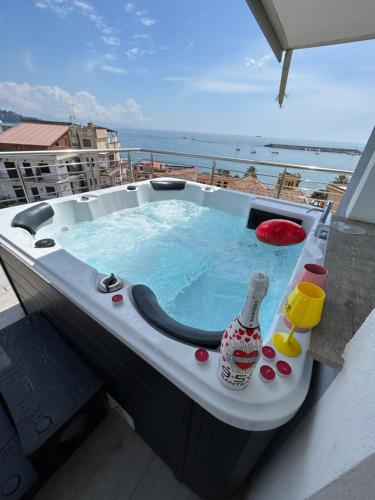 uma banheira de hidromassagem com uma garrafa na varanda em Vista Mare Apartments em Giardini Naxos