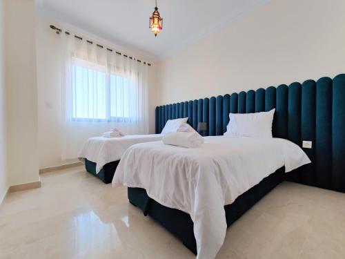 een slaapkamer met 2 bedden en witte lakens bij Appartment in Tanger City Center - 5min to The Beach - Free Parking in Tanger