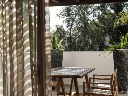 a wooden table and two chairs on a patio at Lindian Village All Inclusive Resort Rhodes,Curio Collection in Kiotari