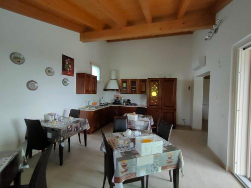 ein Wohnzimmer mit Tischen und Stühlen sowie eine Küche in der Unterkunft Corte del Sole in Valeggio sul Mincio