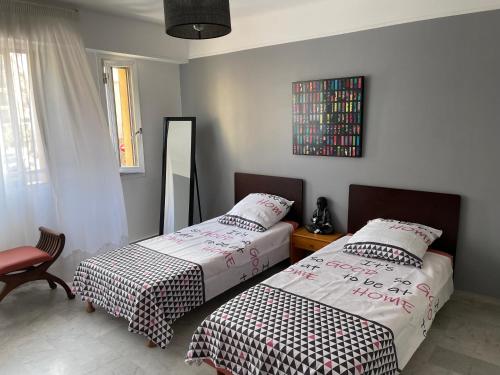 une chambre avec deux lits et un miroir dans l'établissement Centre cannes grand 3 pièces tout à pieds, à Cannes