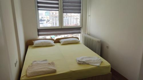 a small bed in a room with a window at Sky view luxury Center Skopje apartments in Skopje