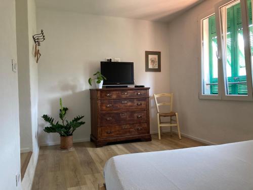 a bedroom with a dresser with a television on it at house in the medieval village in Apricale