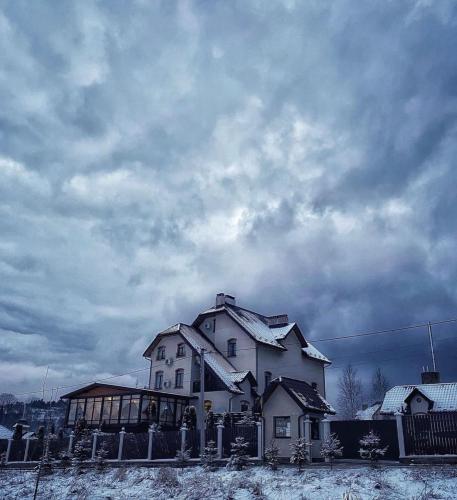 a large white house with snow on it at Villa Grand in Skhidnitsa