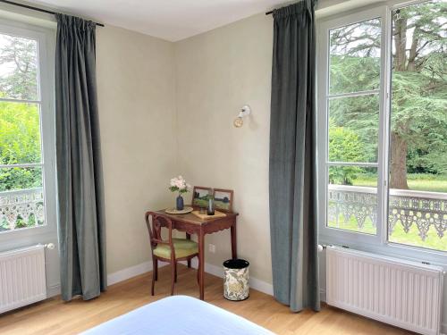 a bedroom with a desk and two windows at Entre les branches in Saint-Règle