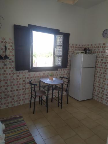 uma cozinha com uma mesa, um frigorífico e uma janela em Patmos house Leo & Mary em Patmos