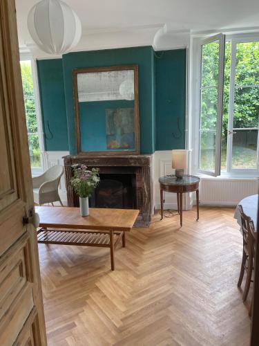 a living room with a fireplace and green walls at Entre les branches in Saint-Règle