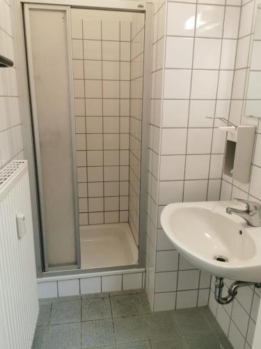 a white bathroom with a shower and a sink at 2 Bett Zimmer in Ramstein-Miesenbach