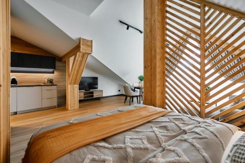 a bedroom with a large bed and a staircase at Tatra Nest Apartamenty - jacuzzi, sauna! in Biały Dunajec