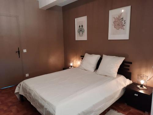 une chambre avec un grand lit blanc avec deux lampes dans l'établissement LOCATION MAROTY, à Manosque