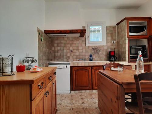 une cuisine avec des armoires en bois et un four blanc dans l'établissement LOCATION MAROTY, à Manosque