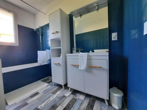 La salle de bains bleue est pourvue d'un lavabo et d'une baignoire. dans l'établissement LOCATION MAROTY, à Manosque