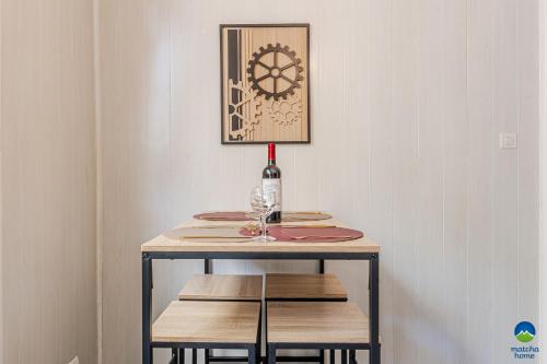 a table with a bottle of wine and a wine glass at CATTENOM NEW NOVÝ NOWY НОВИЙ - 3 min Parking, Wi-Fi, Nespresso - Repos assuré, calme & confort - Rest guaranteed, quiet & comfy in Hayange