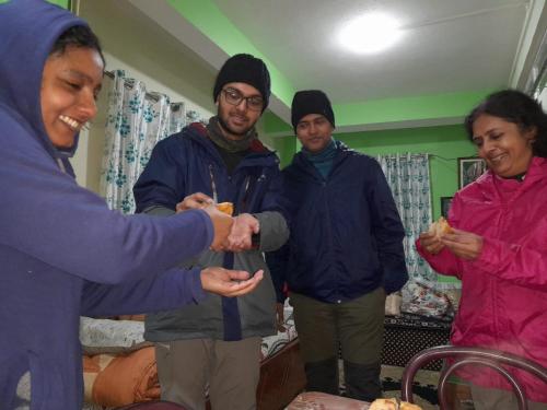 a group of people shaking hands in a room at International Youth Hostel and Homestay Kurseong Bazar in Kurseong