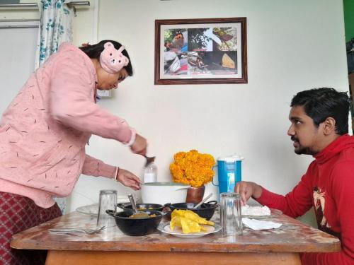 a woman in a pig costume preparing food at a table at International Youth Hostel and Homestay Kurseong Bazar in Kurseong