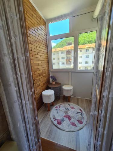 a small room with two stools and a window at Garsoniera Slanic-Moldova in Slănic-Moldova