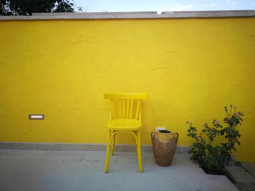 una silla amarilla sentada frente a una pared amarilla en DonaLisa en Andrano