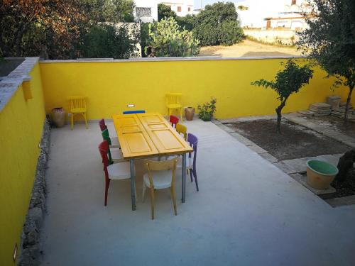 uma mesa e cadeiras em frente a uma parede amarela em DonaLisa em Andrano