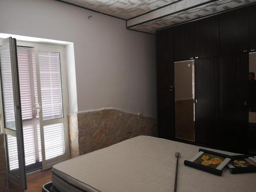 um quarto com uma cama e uma grande janela em Porzione di Casale Ultima Spiaggia em Graticciare