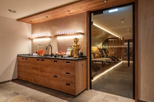 a kitchen with a sink and a living room at Hotel Pramstraller in Mayrhofen