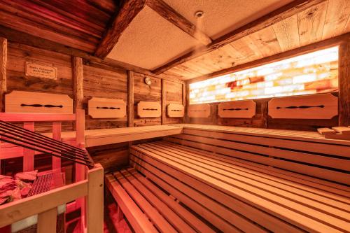 a large empty sauna with chairs and a window at Hotel Pramstraller in Mayrhofen