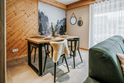 a dining room with a table and a couch at Apartamenty Krokus przy Polanie Biały Potok in Witów