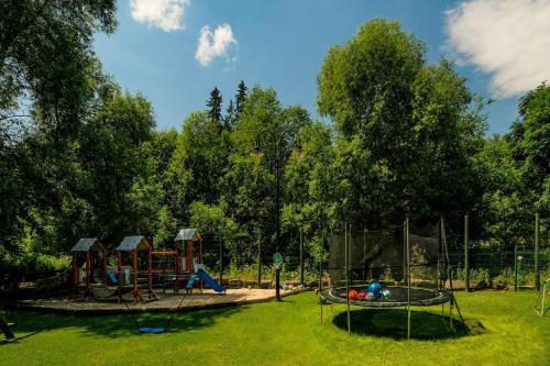a park with a playground with slides and swings at Aparthotel Góralski Spa 2 in Białka Tatrzanska