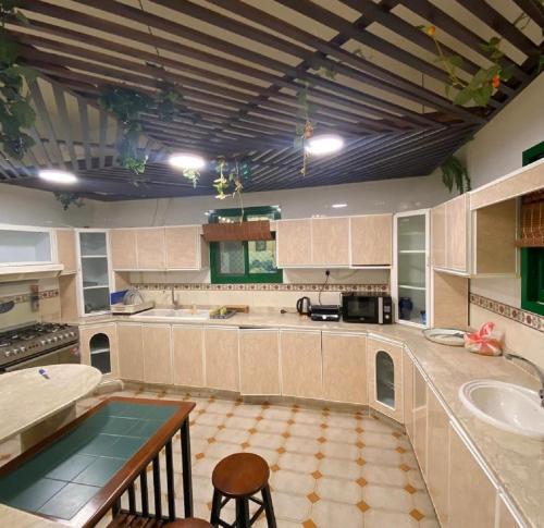 a large kitchen with a table and a sink at Bedya Farm in Khor Fakkan