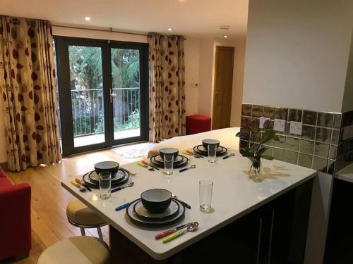 a kitchen with a table with plates and glasses on it at Fantastic Cotswolds hideaway Cleeve Hill in Southam