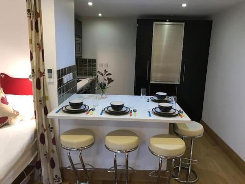 a kitchen with a table with four chairs and a bed at Fantastic Cotswolds hideaway Cleeve Hill in Southam
