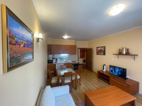 sala de estar y cocina con sofá y mesa en Ski-in ski-out Fantastic Apartament en Bansko