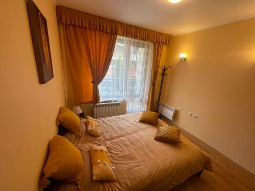 a bedroom with a bed with pillows and a window at Ski-in ski-out Fantastic Apartament in Bansko