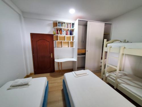 a small room with two bunk beds and a book shelf at Top view hostel in Durrës