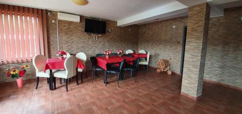 un comedor con mesas rojas y sillas blancas en Casa Darian, en Dubova