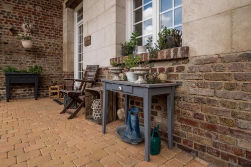 a patio with a table with potted plants on it at gîte Cosy Green 2 in Chevincourt