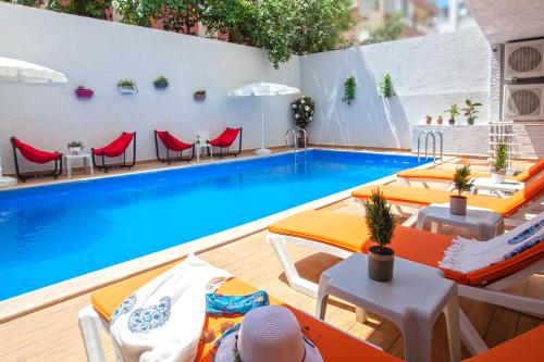 a swimming pool with tables and chairs next to a pool at Old Town Point Hotel & Spa Antalya in Antalya