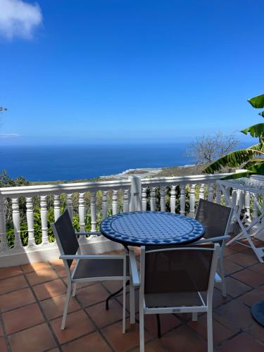 een tafel en stoelen op een balkon met uitzicht op de oceaan bij Casa Buena Vista in Jedey