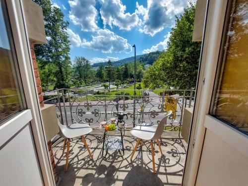 een balkon met een tafel en stoelen en uitzicht bij Apartament Pułaskiego in Krynica Zdrój