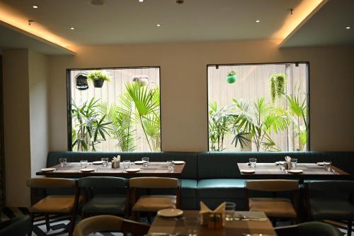 a restaurant with two tables and a green couch at Sachika Hotels, Guwahati in Guwahati